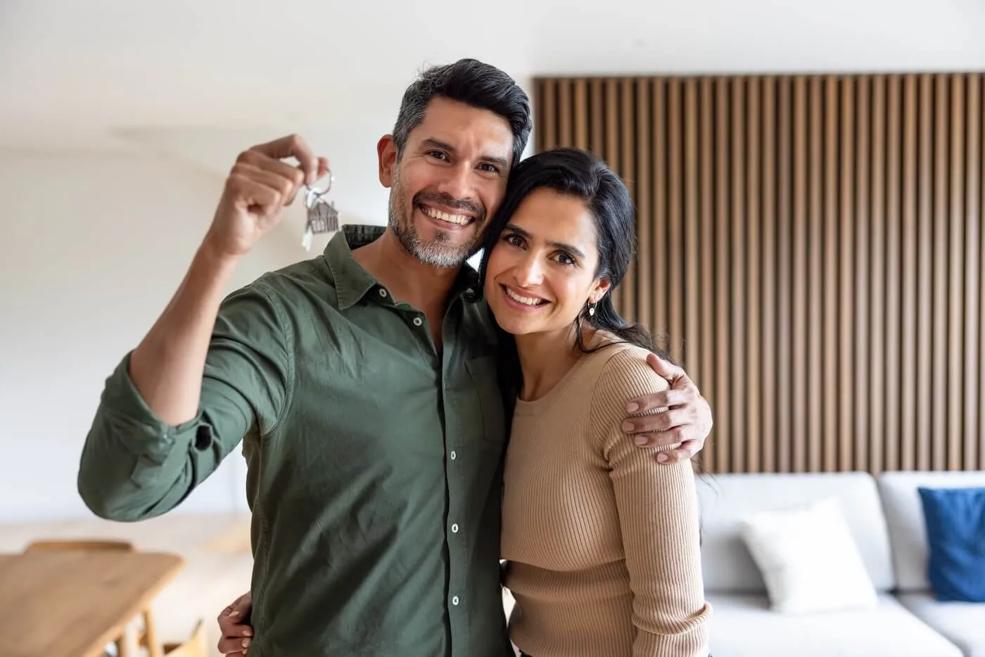 Happy couple holding the keys from their new house